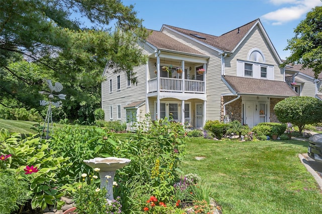 41 Millholland Dr, Fishkill, NY 12524 - view of front facade featuring stone siding, a front lawn, a balcony, and roof with shingles