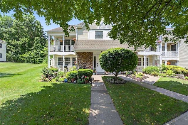 41 Millholland Dr, Fishkill, NY 12524 - view of front of property featuring a front yard, stone siding, roof with shingles, and a balcony