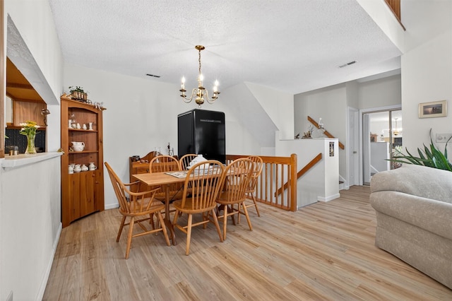 41 Millholland Dr, Fishkill, NY 12524 - dining room with light wood-style flooring, a chandelier, and a textured ceiling