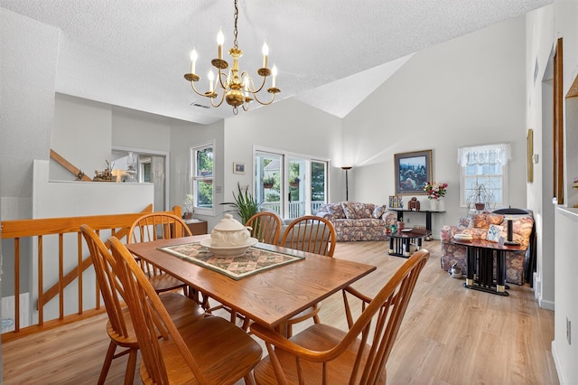 41 Millholland Dr, Fishkill, NY 12524 - dining space featuring a textured ceiling, light wood-style floors, a chandelier, and high vaulted ceiling