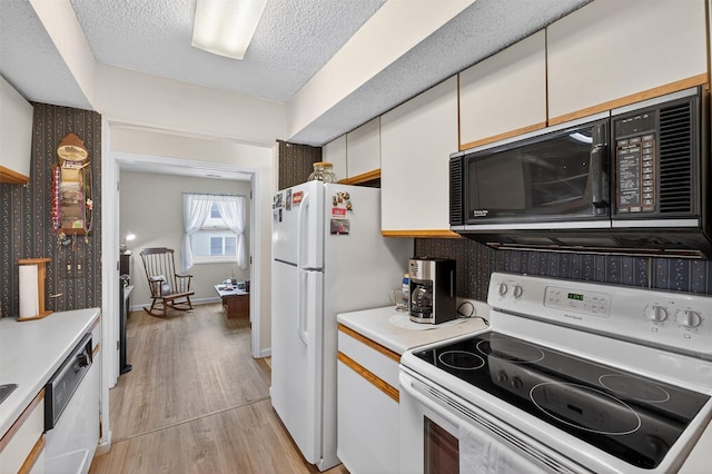 41 Millholland Dr, Fishkill, NY 12524 - kitchen with white appliances, white cabinets, light wood-style floors, light countertops, and a textured ceiling