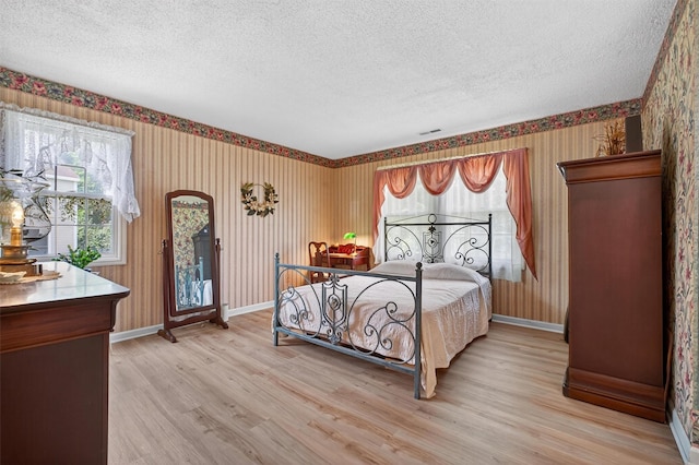 41 Millholland Dr, Fishkill, NY 12524 - bedroom featuring wallpapered walls, a textured ceiling, light wood-style floors, and access to outside