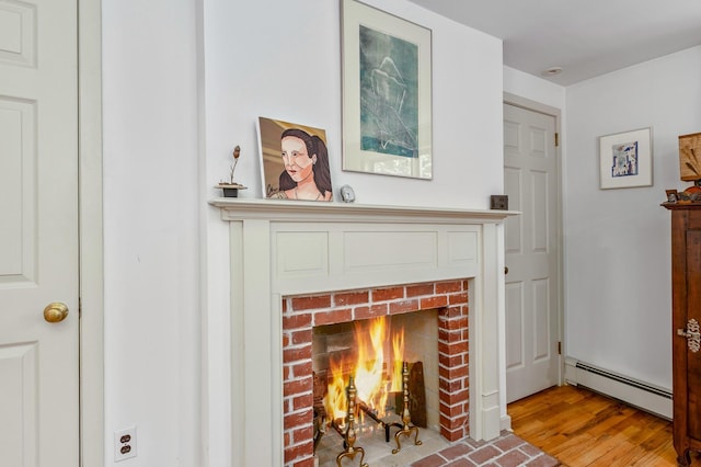 5 Shore Dr, Setauket, NY 11733 - detailed view of a baseboard radiator, a fireplace, and wood finished floors