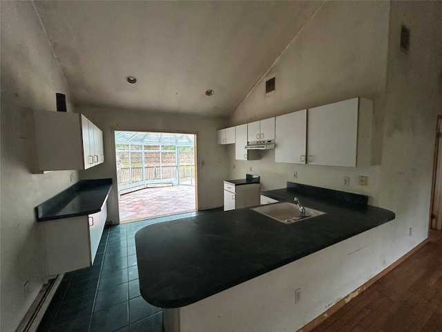 291 Locust Dr, Rocky Point, NY 11778 - kitchen featuring dark countertops, white cabinets, under cabinet range hood, a peninsula, and high vaulted ceiling