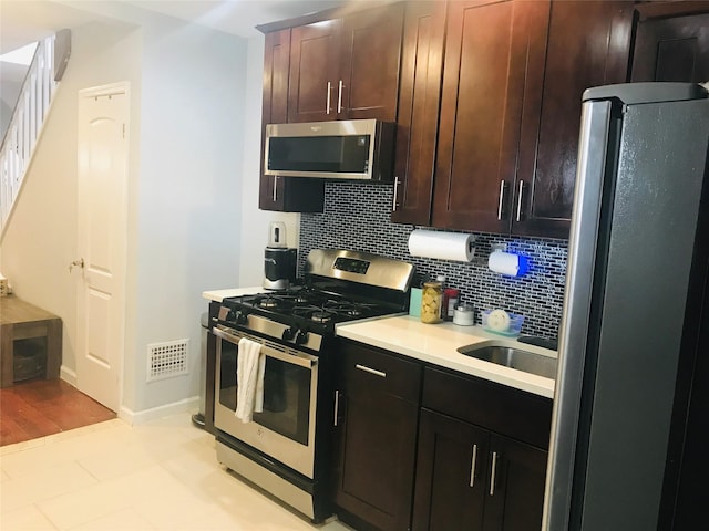 92-38 77th St, Woodhaven, NY 11421 - kitchen with appliances with stainless steel finishes, decorative backsplash, light countertops, and dark brown cabinets