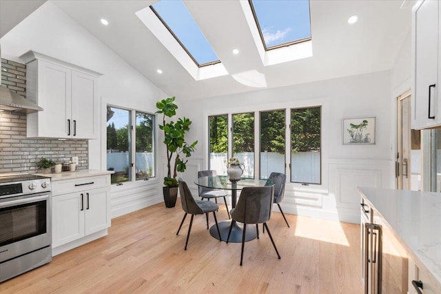 77 Bounty Ln, Jericho, NY 11753 - dining area featuring a skylight, a decorative wall, light wood-type flooring, a wainscoted wall, and recessed lighting