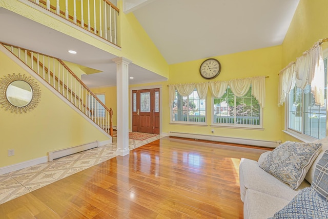 239 Walnut Rd, Glen Cove, NY 11542 - entrance foyer featuring a baseboard radiator, ornate columns, high vaulted ceiling, baseboard heating, and wood finished floors