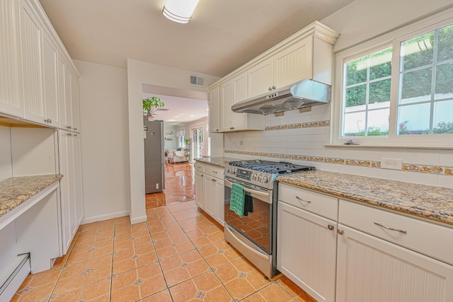 239 Walnut Rd, Glen Cove, NY 11542 - kitchen with stainless steel gas range oven, under cabinet range hood, plenty of natural light, and backsplash