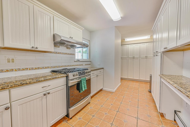 239 Walnut Rd, Glen Cove, NY 11542 - kitchen with stainless steel range with gas cooktop, under cabinet range hood, tasteful backsplash, light stone countertops, and light tile patterned flooring