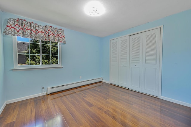 239 Walnut Rd, Glen Cove, NY 11542 - unfurnished bedroom featuring a baseboard radiator, wood finished floors, and a closet