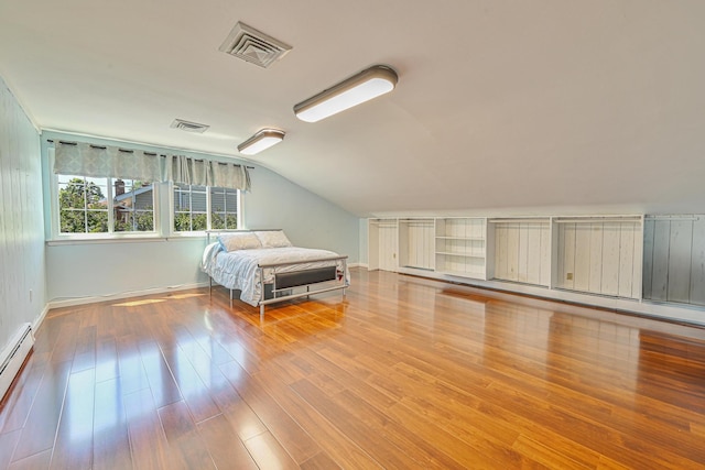 239 Walnut Rd, Glen Cove, NY 11542 - bedroom with vaulted ceiling, wood finished floors, and a baseboard heating unit