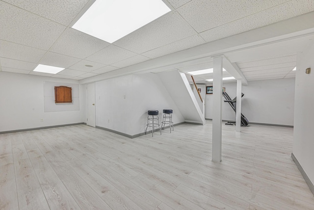 239 Walnut Rd, Glen Cove, NY 11542 - finished basement featuring a paneled ceiling, stairs, and wood finished floors