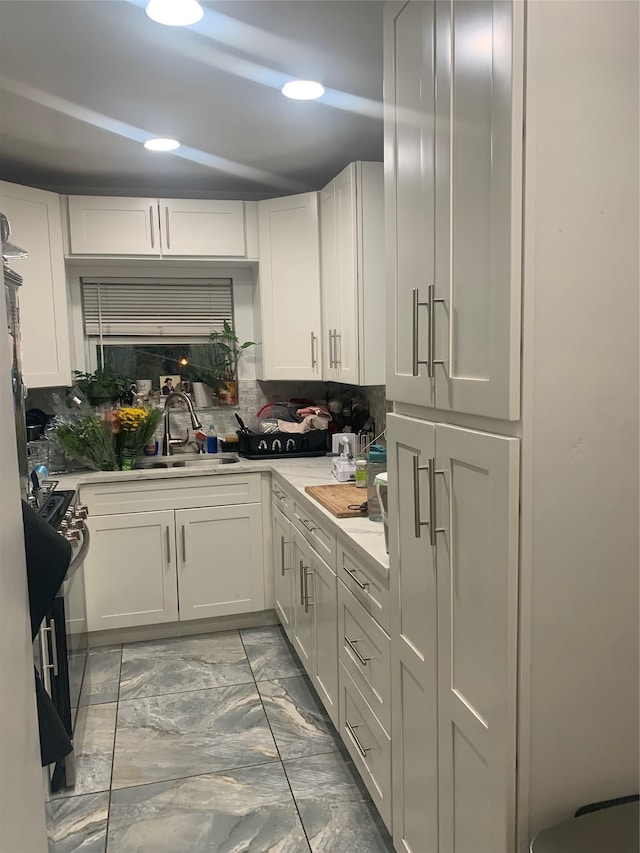 14451 68th Ave, Kew Garden Hills, NY 11367 - kitchen featuring white cabinets, light marble finish flooring, light countertops, and tasteful backsplash