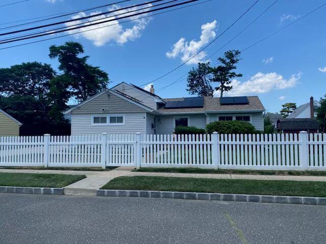 4 Meadow Dr, Bay Shore, NY 11706 - ranch-style house with solar panels and a fenced front yard
