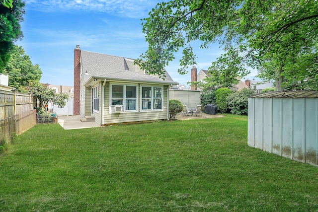 662 Rose Blvd, Baldwin, NY 11510 - back of house with a patio area, a storage unit, a chimney, a fenced backyard, and roof with shingles