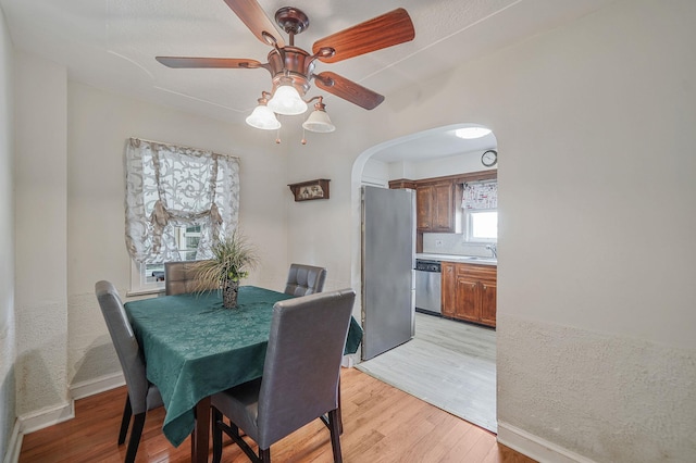 662 Rose Blvd, Baldwin, NY 11510 - dining area with light wood-style floors, arched walkways, and a ceiling fan