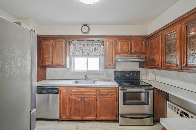 662 Rose Blvd, Baldwin, NY 11510 - kitchen with stainless steel appliances, under cabinet range hood, light countertops, and light wood-type flooring