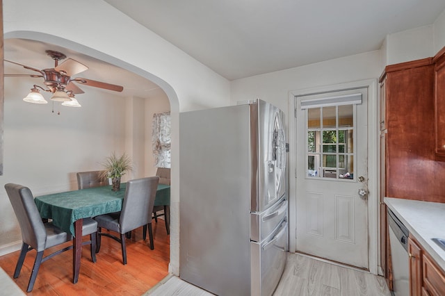 662 Rose Blvd, Baldwin, NY 11510 - kitchen with stainless steel fridge, ceiling fan, arched walkways, light wood-type flooring, and light countertops