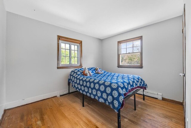 565 Barley Ln, Southold, NY 11971 - bedroom featuring wood finished floors and baseboard heating