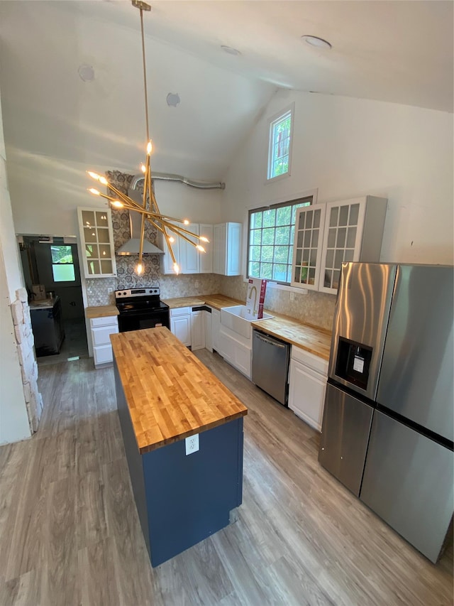57 Chestnut St, Beach Lake, NY 13865 - kitchen with appliances with stainless steel finishes, butcher block countertops, white cabinets, high vaulted ceiling, and tasteful backsplash
