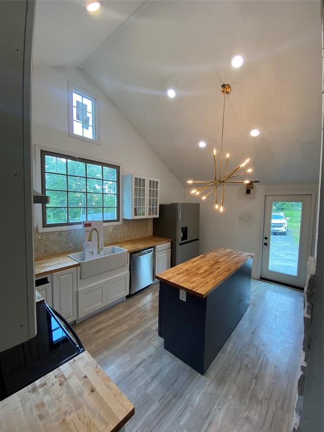 57 Chestnut St, Beach Lake, NY 13865 - kitchen with appliances with stainless steel finishes, butcher block countertops, a chandelier, white cabinets, and backsplash