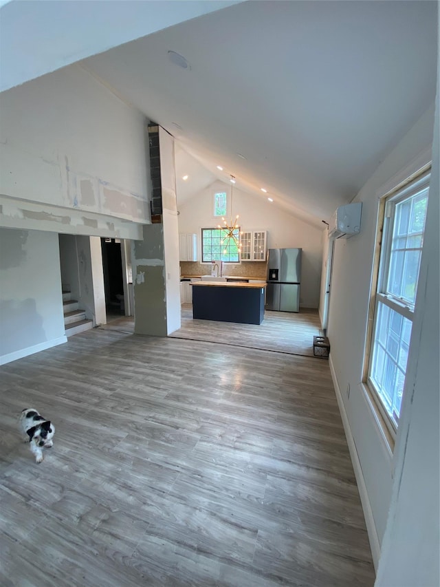 57 Chestnut St, Beach Lake, NY 13865 - unfurnished living room featuring lofted ceiling, a chandelier, plenty of natural light, and wood finished floors