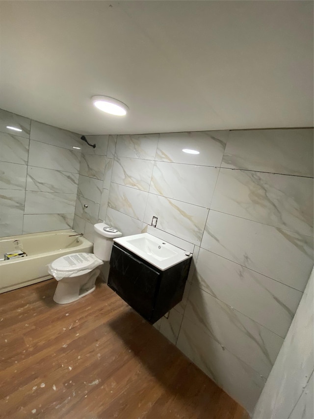 57 Chestnut St, Beach Lake, NY 13865 - bathroom with tile walls, wood finished floors, vanity, and shower / washtub combination