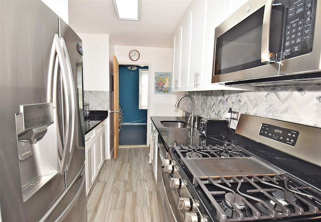 18-70 211th St Unit 5K, Bayside, NY 11360 - kitchen featuring appliances with stainless steel finishes, white cabinetry, tasteful backsplash, dark stone countertops, and light wood-style floors