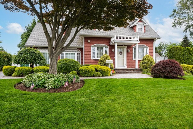 18 Loring Rd, Levittown, NY 11756 - view of front facade with roof with shingles and a front yard