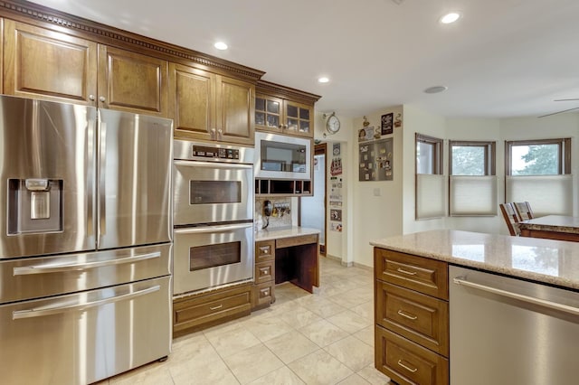 18 Loring Rd, Levittown, NY 11756 - kitchen featuring stainless steel appliances, light stone countertops, light tile patterned floors, glass insert cabinets, and recessed lighting