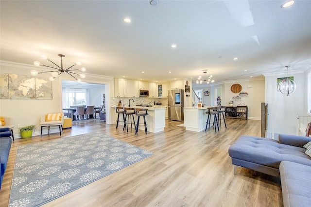 615 Pearl St, Oceanside, NY 11572 - living room with a chandelier, crown molding, recessed lighting, and light wood-style floors