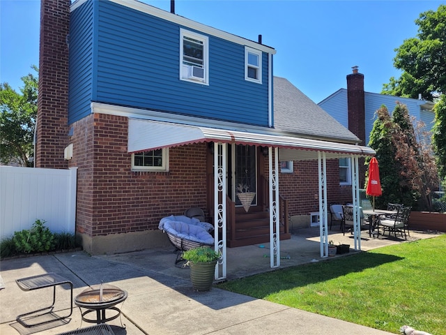 422 Saint Agnes Pl, Franklin Square, NY 11010 - rear view of house with brick siding, a chimney, a patio area, and a fire pit