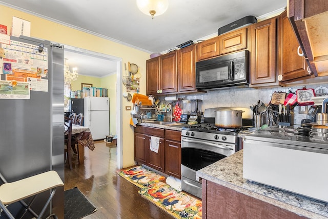 15 E Walnut St, Central Islip, NY 11722 - kitchen featuring stainless steel appliances, ornamental molding, wood finished floors, light countertops, and tasteful backsplash