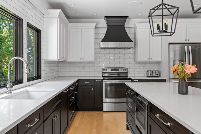 9 Guthrie Ct, East Northport, NY 11731 - kitchen featuring stainless steel appliances, custom exhaust hood, white cabinets, tasteful backsplash, and recessed lighting