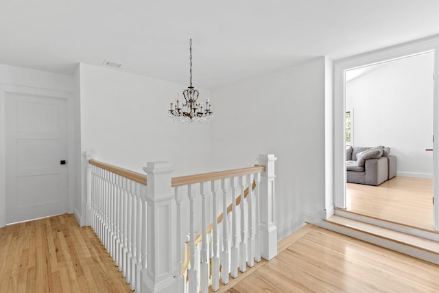 9 Guthrie Ct, East Northport, NY 11731 - hallway featuring an upstairs landing, light wood finished floors, and a chandelier