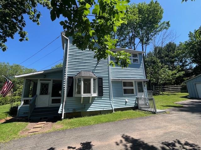 39 Winslow Pl, Liberty, NY 12754 - view of front facade with a sunroom, entry steps, and an outbuilding