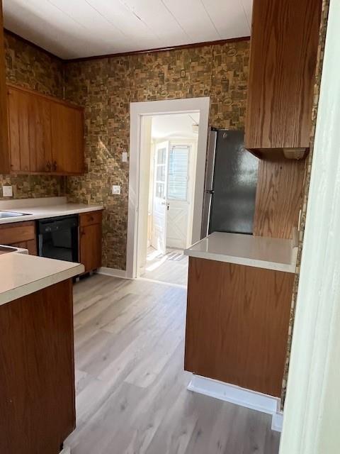 39 Winslow Pl, Liberty, NY 12754 - kitchen featuring brown cabinetry, freestanding refrigerator, dishwasher, light wood-style floors, and light countertops