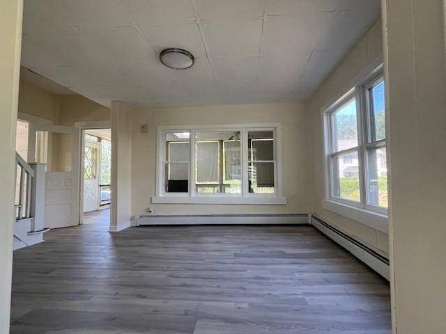 39 Winslow Pl, Liberty, NY 12754 - empty room with a baseboard heating unit, wood finished floors, and stairway