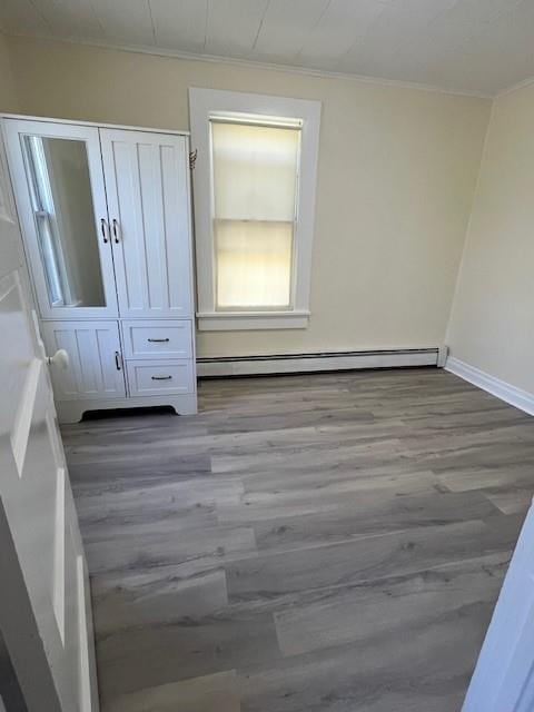 39 Winslow Pl, Liberty, NY 12754 - unfurnished bedroom featuring baseboard heating, wood finished floors, crown molding, and a closet