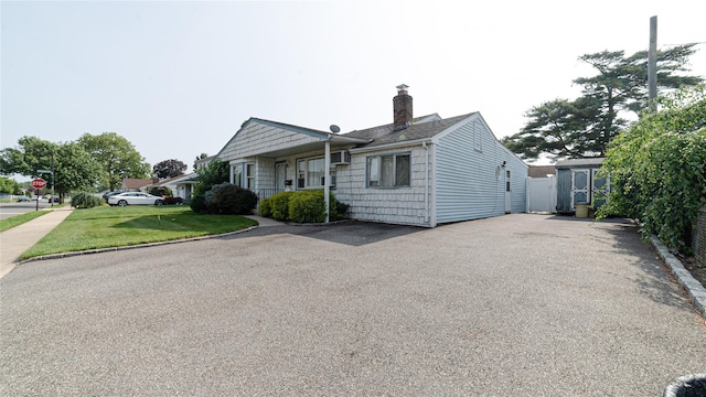 14 Lois Ln, Farmingdale, NY 11735 - bungalow-style home featuring a chimney, driveway, a front lawn, and a shingled roof
