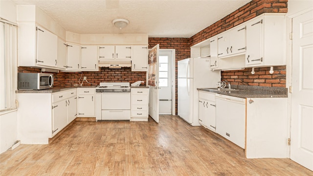 14 Lois Ln, Farmingdale, NY 11735 - kitchen with white appliances, light wood-type flooring, dark countertops, white cabinetry, and brick wall