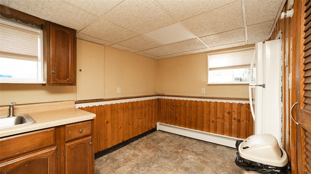14 Lois Ln, Farmingdale, NY 11735 - kitchen featuring a baseboard heating unit, a drop ceiling, freestanding refrigerator, brown cabinets, and light countertops