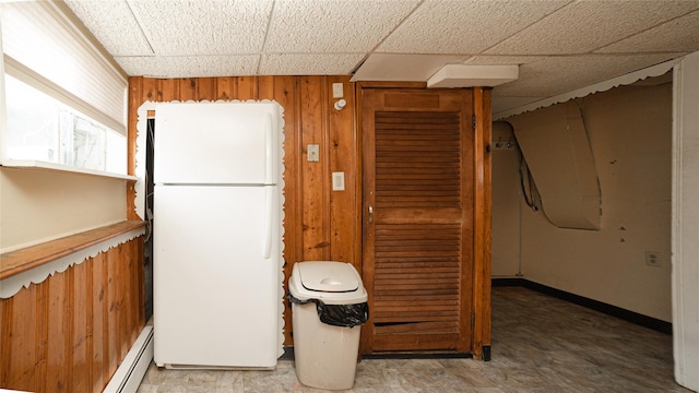 14 Lois Ln, Farmingdale, NY 11735 - kitchen featuring freestanding refrigerator, a paneled ceiling, wooden walls, and baseboard heating
