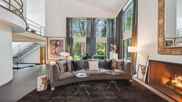 living area with high vaulted ceiling and stairs