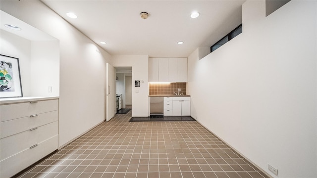kitchen with white cabinetry, recessed lighting, decorative backsplash, and light countertops