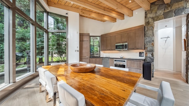 dining room with a wooden ceiling with exposed beams and light wood-style flooring
