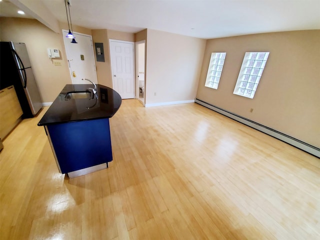 83-75 117th St Unit 2D, Kew Gardens, NY 11418 - kitchen featuring dark countertops, freestanding refrigerator, light wood finished floors, and a kitchen island with sink