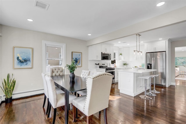 10 Branch Pl, Roosevelt, NY 11575 - dining room featuring baseboard heating, dark wood-type flooring, and recessed lighting