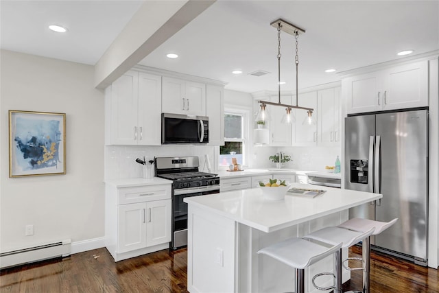 10 Branch Pl, Roosevelt, NY 11575 - kitchen with appliances with stainless steel finishes, a baseboard radiator, dark wood-style flooring, white cabinetry, and recessed lighting