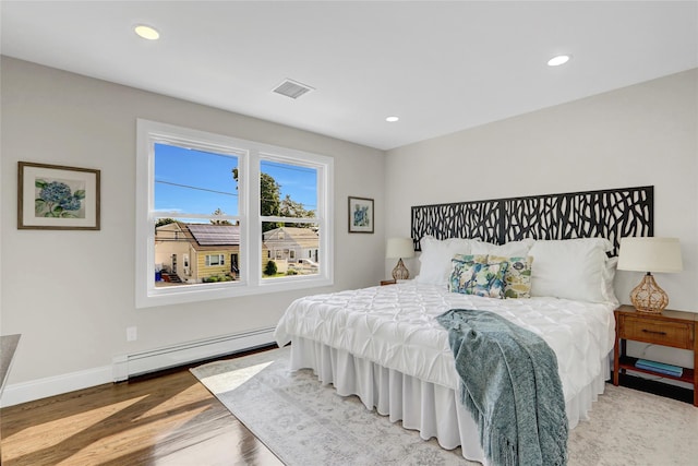 10 Branch Pl, Roosevelt, NY 11575 - bedroom with a baseboard heating unit, recessed lighting, and light wood-type flooring